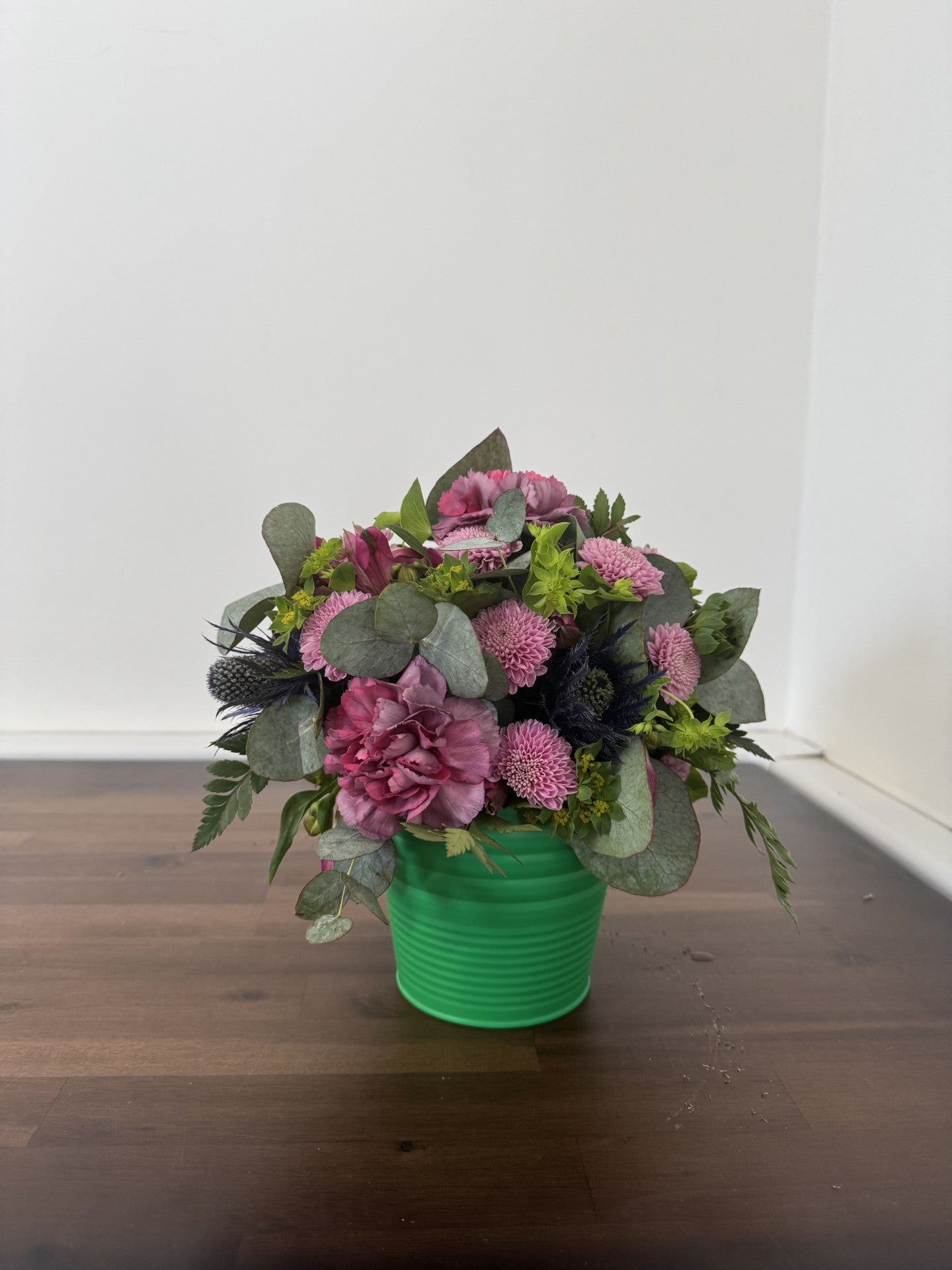 Floral table arrangement in a green pot 